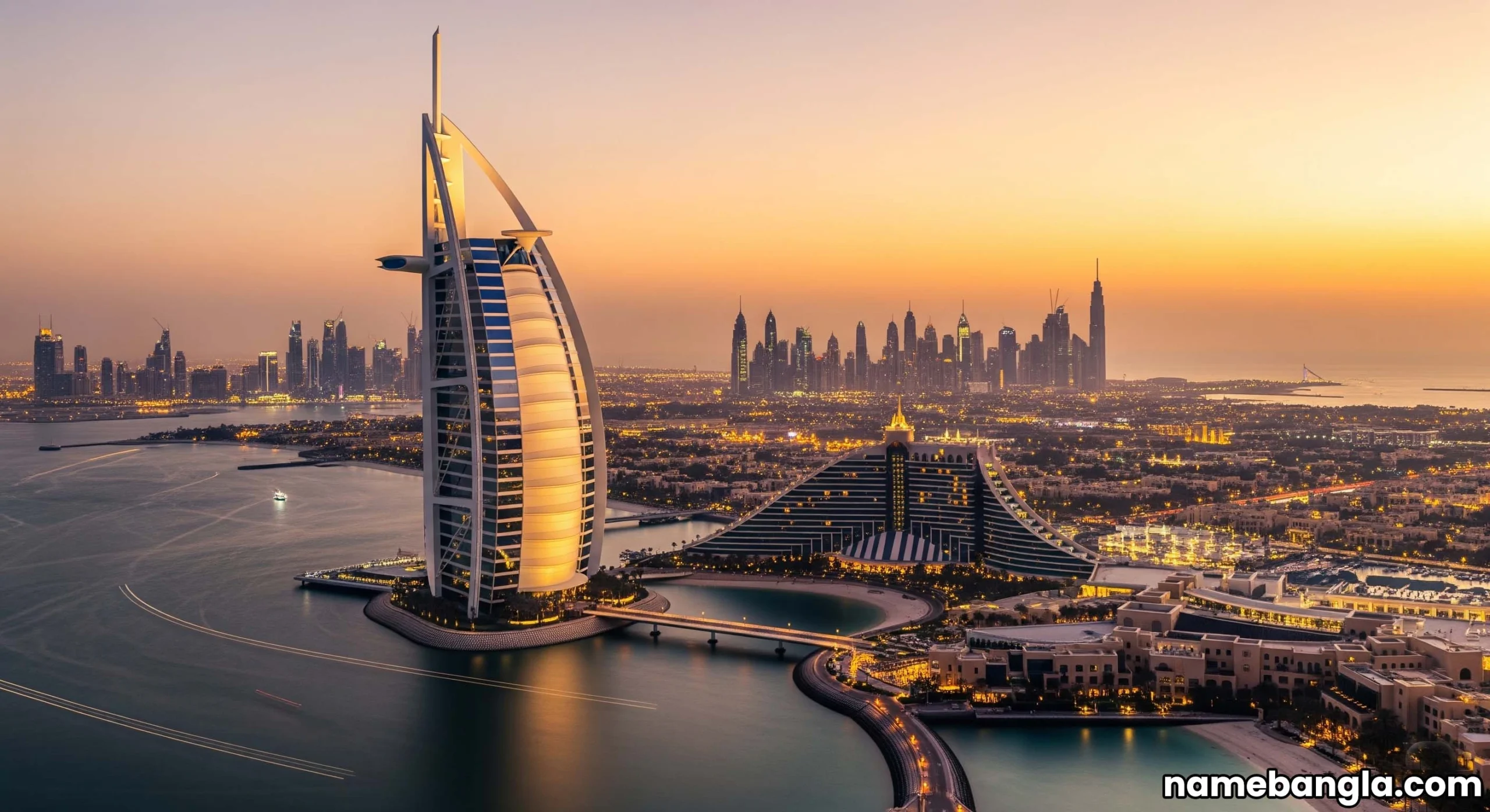 Burj Al Arab Jumeirah at sunset with city lights, iconic Dubai luxury hotel.