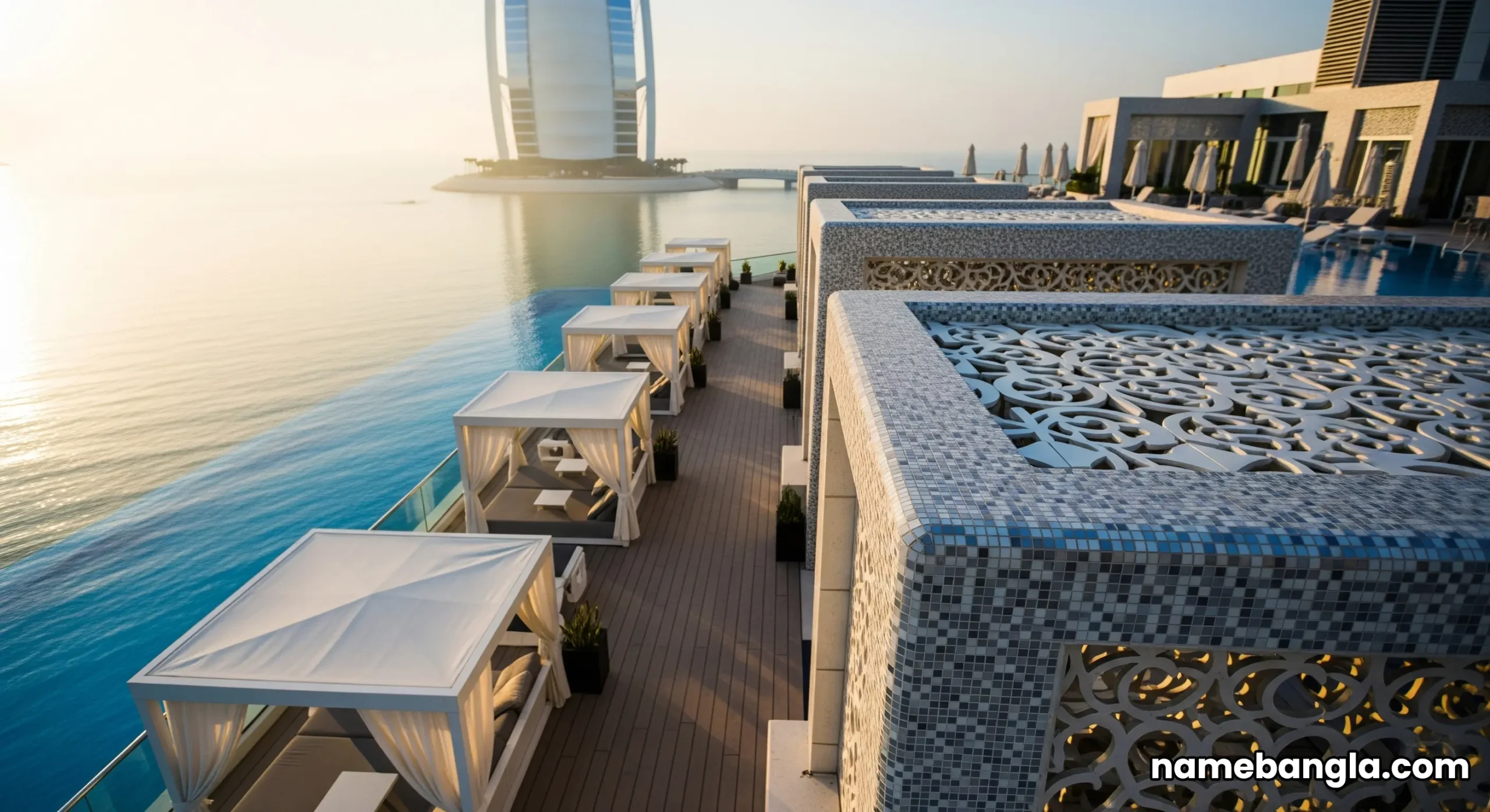 Wide aerial view of the Burj Al Arab Terrace at sunrise, showing its scale against the blue ocean and the iconic hotel.