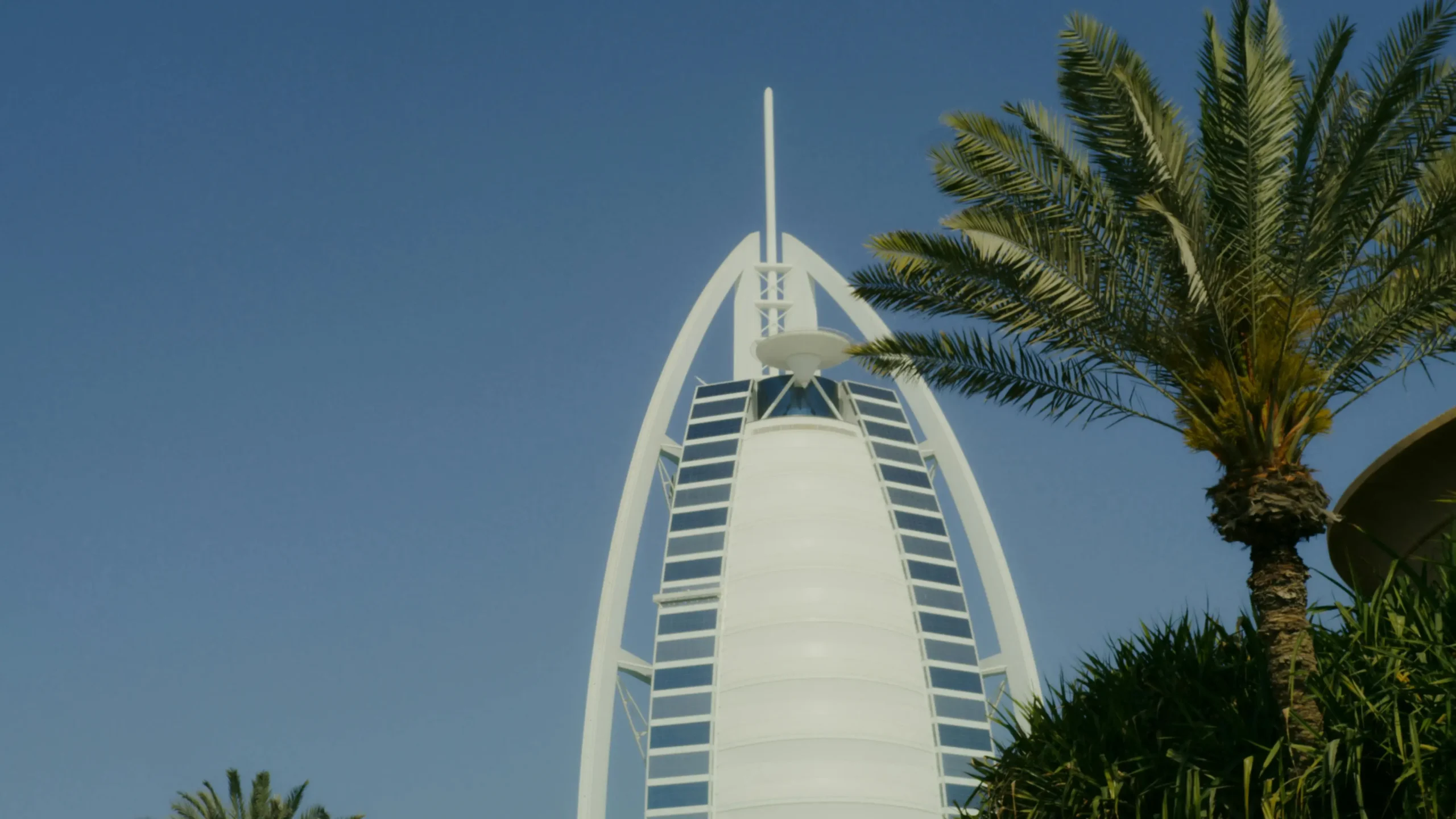The iconic sail-shaped Burj Al Arab hotel illuminated at night.