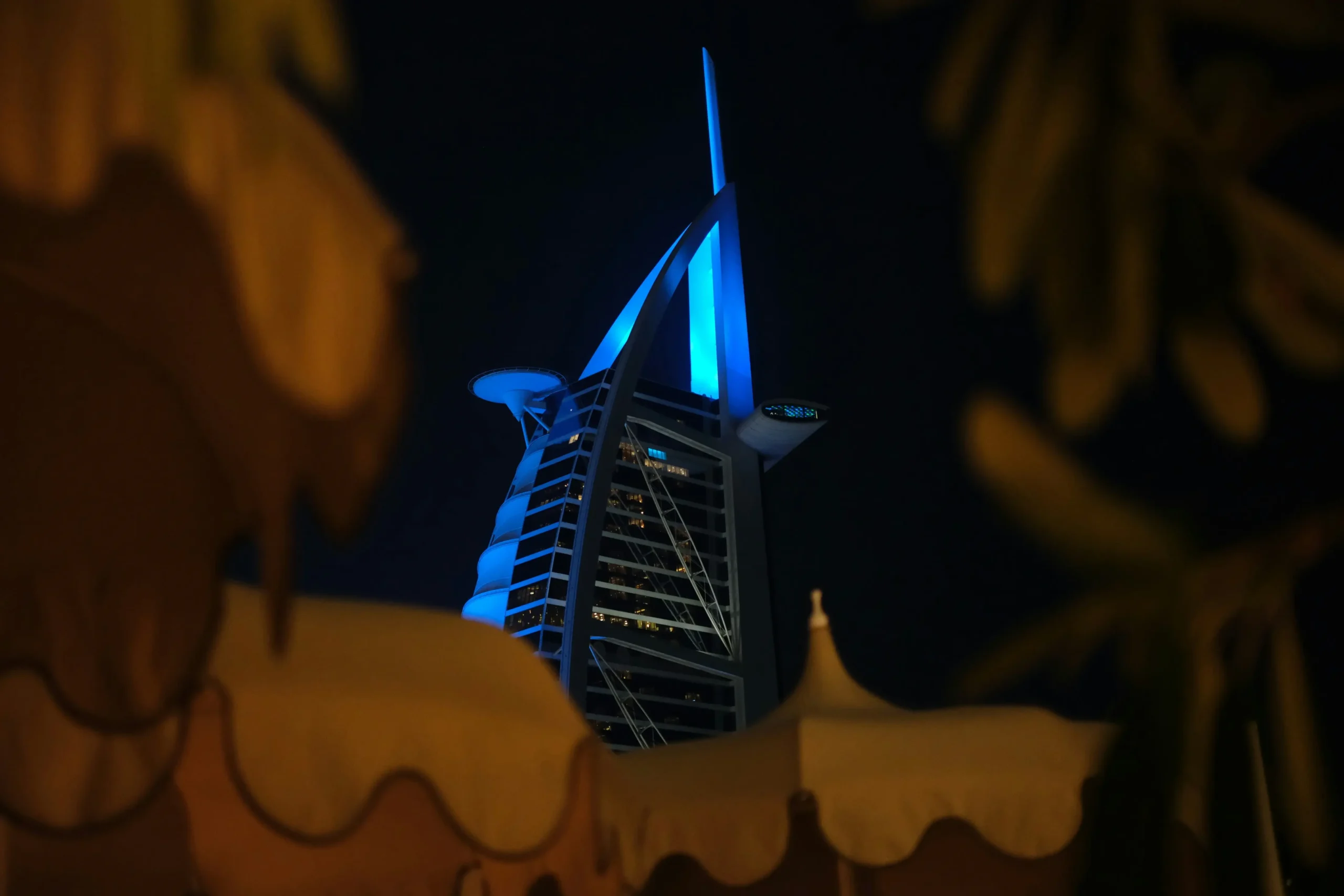 The iconic Burj Al Arab hotel illuminated at dusk, a symbol of luxury for a honeymoon or anniversary.